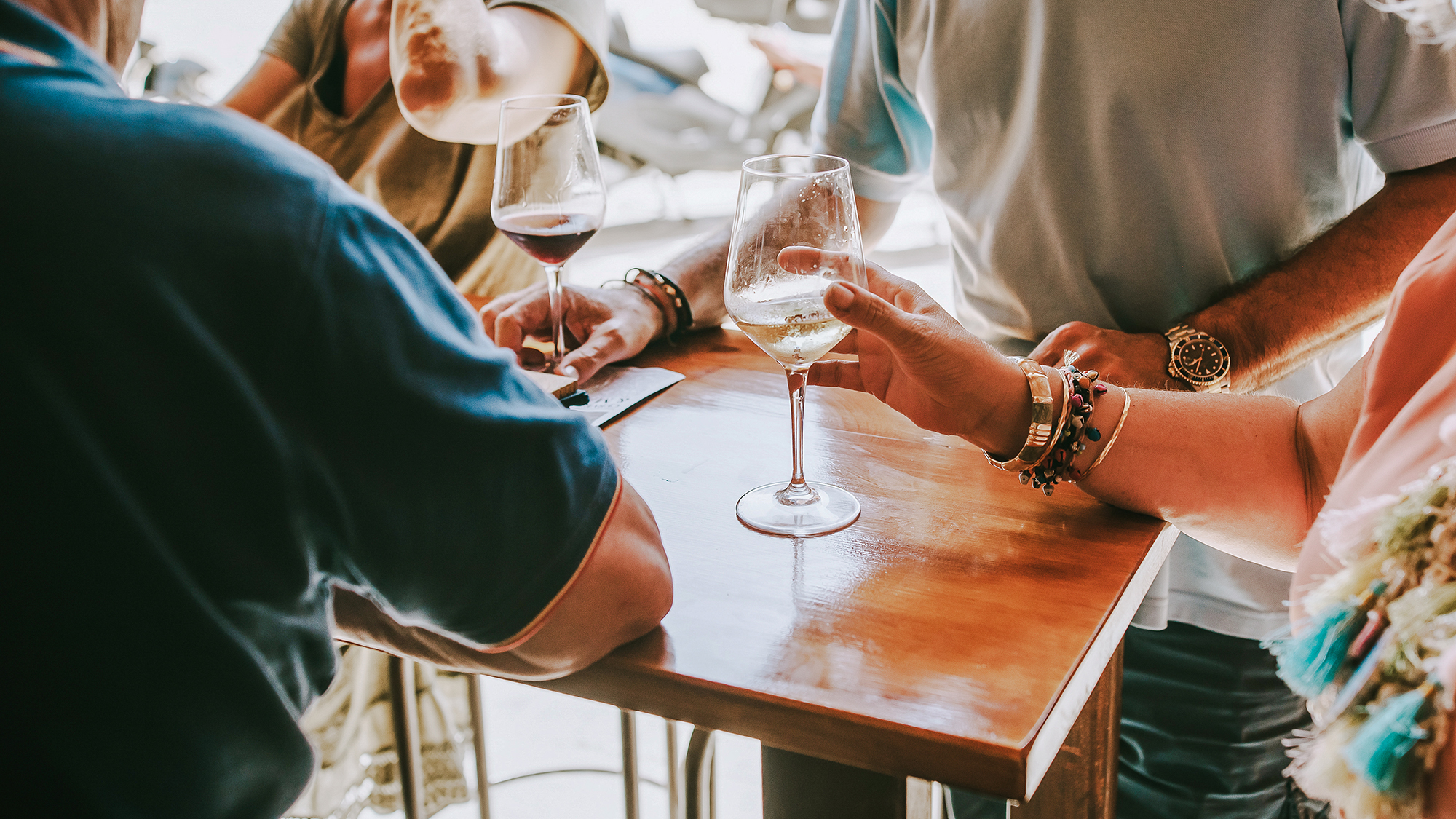 On a sunny day, people eat cheese and drink wine in the terrace restaurant. A table in a restaurant full of customers.